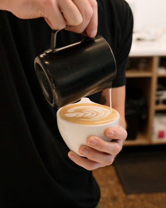 Micro-foamed milk poured into specialty espresso drink at Coalescence Coffee