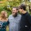 Three people smiling together outdoors in casual setting